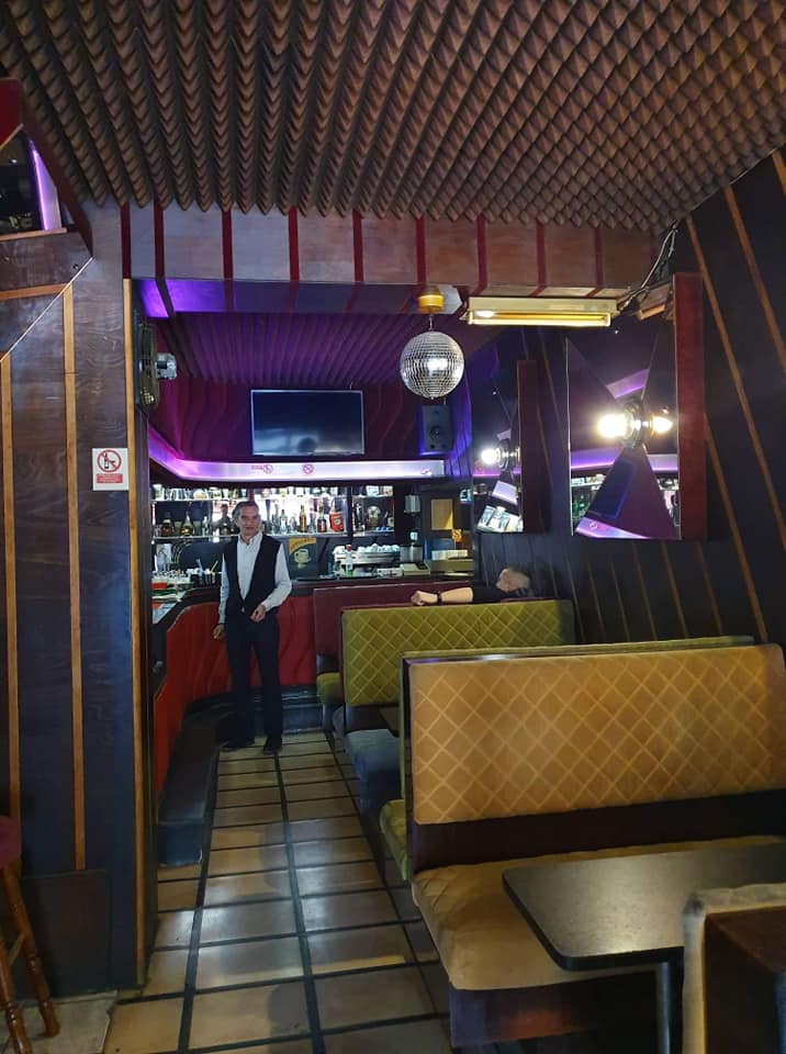 na slici se nalazi enterijer kafica i konobar